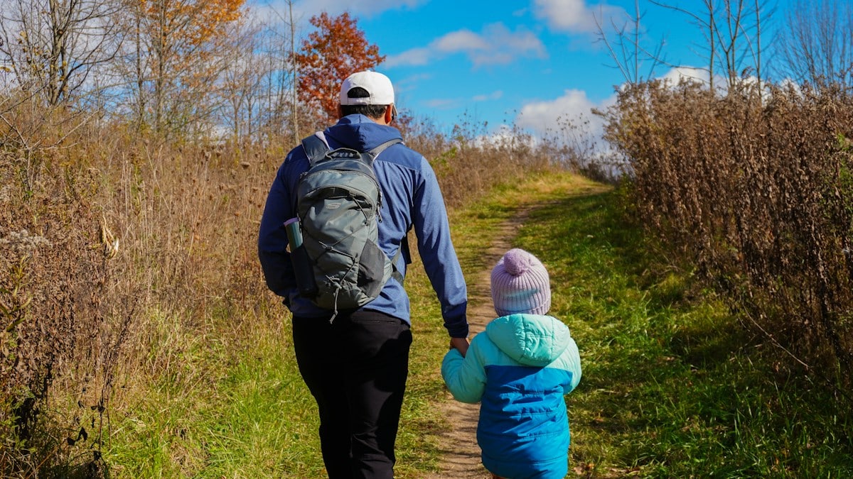 A man and a child walking down a path